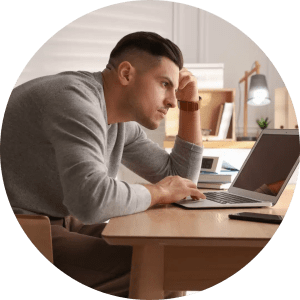5 Everyday Habits That Could Be Causing Your Hip Pain 2 Man with bad posture, slumped over his desk